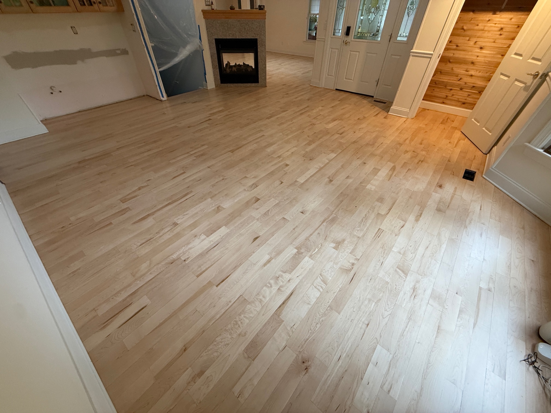 Freshly sanded maple floor ready for finish in an open living and dining room