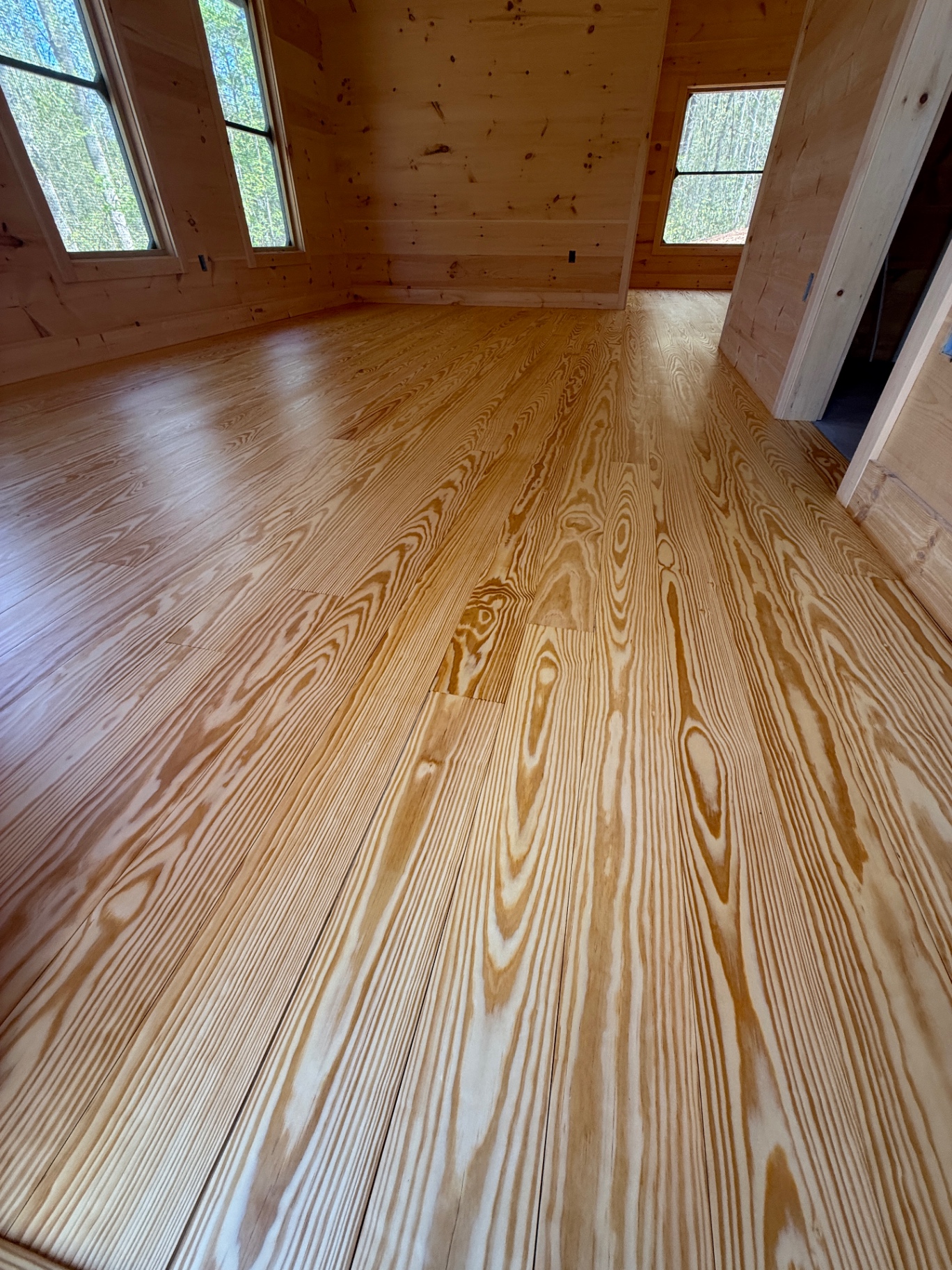 Newly installed and finished heart pine plank floor in a Western North Carolina cabin