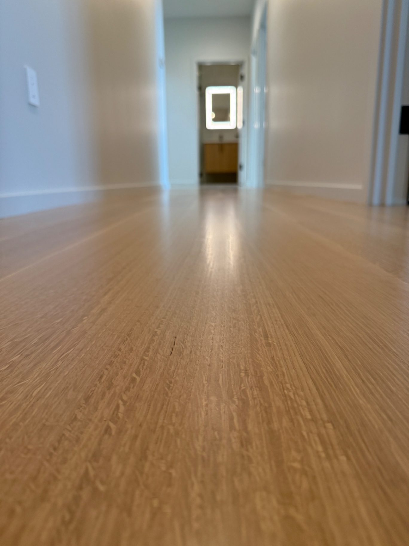 Clean, well-maintained quartersawn white oak hallway floor reflecting daylight
