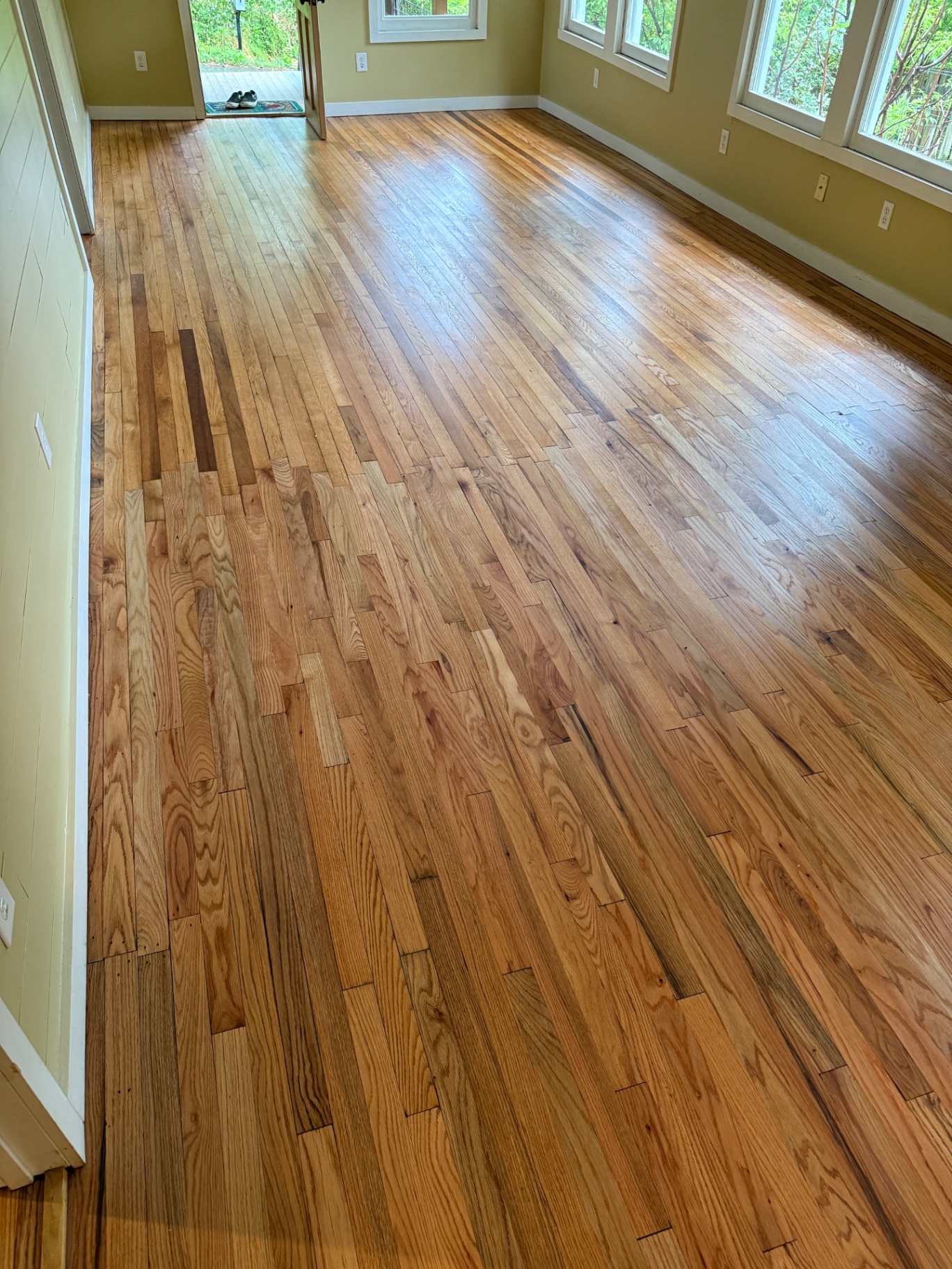 Freshly refinished red oak floor with a clear satin finish in a sunlit Western North Carolina living room
